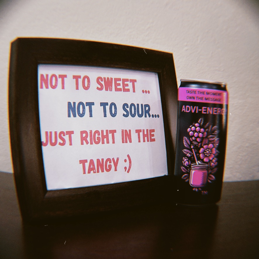 Framed ADVI slogan next to an ADVI-ENERGY Tangy Raspberry can